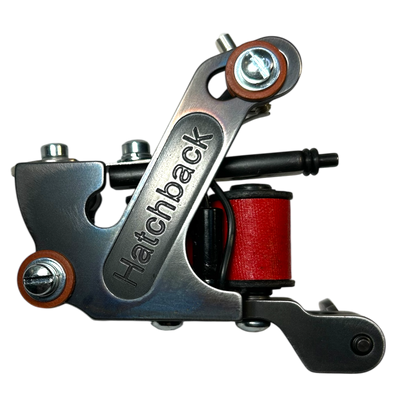 Hatchback traditional coil tattoo machine with red wrap coils and steel frame
